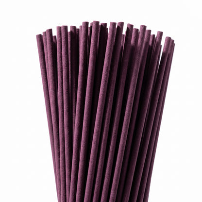 A bundle of slowwy handcrafted japanese incense sticks arranged in a neat fan shape against a solid white background.
