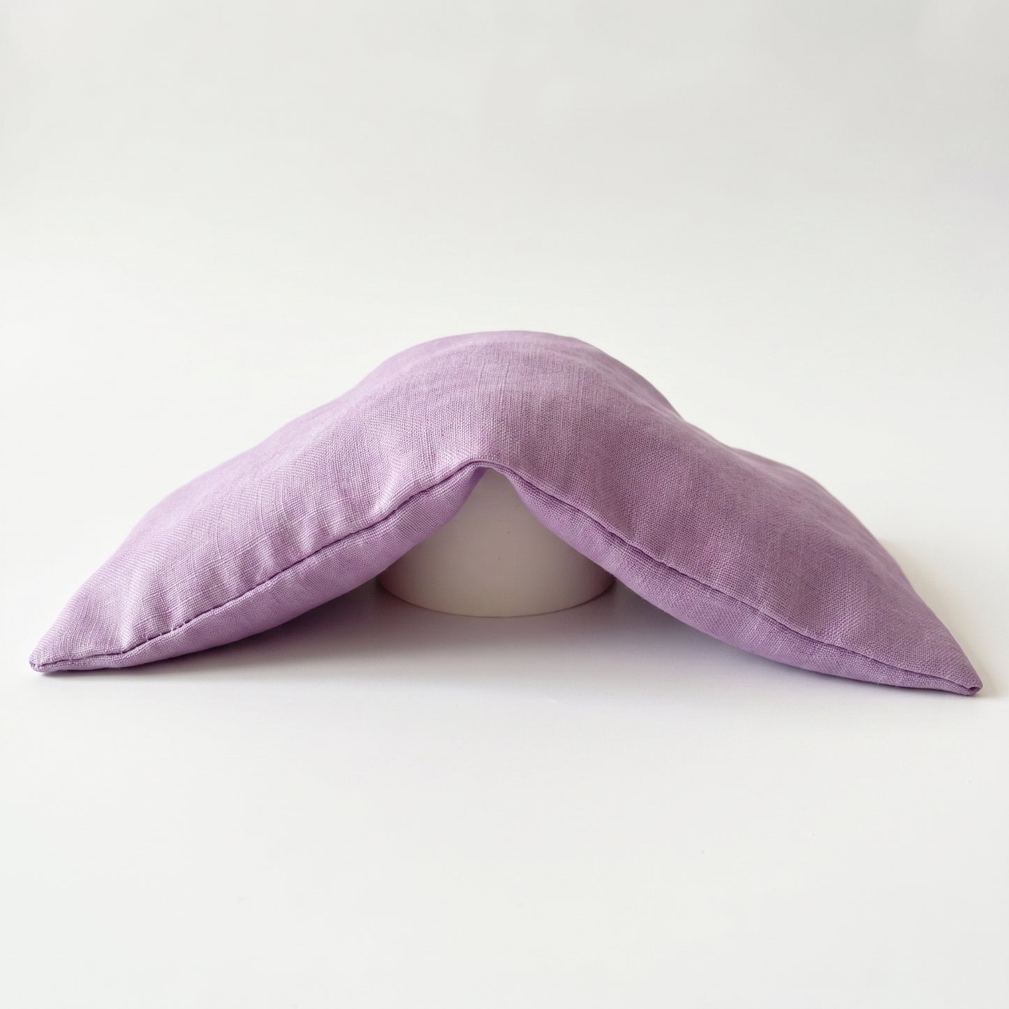 Purple pillow shaped like a mustache on a white background